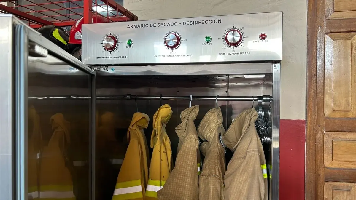 Armario Vulcanus de desinfección y secado abierto y cargado con chaquetones de bomberos