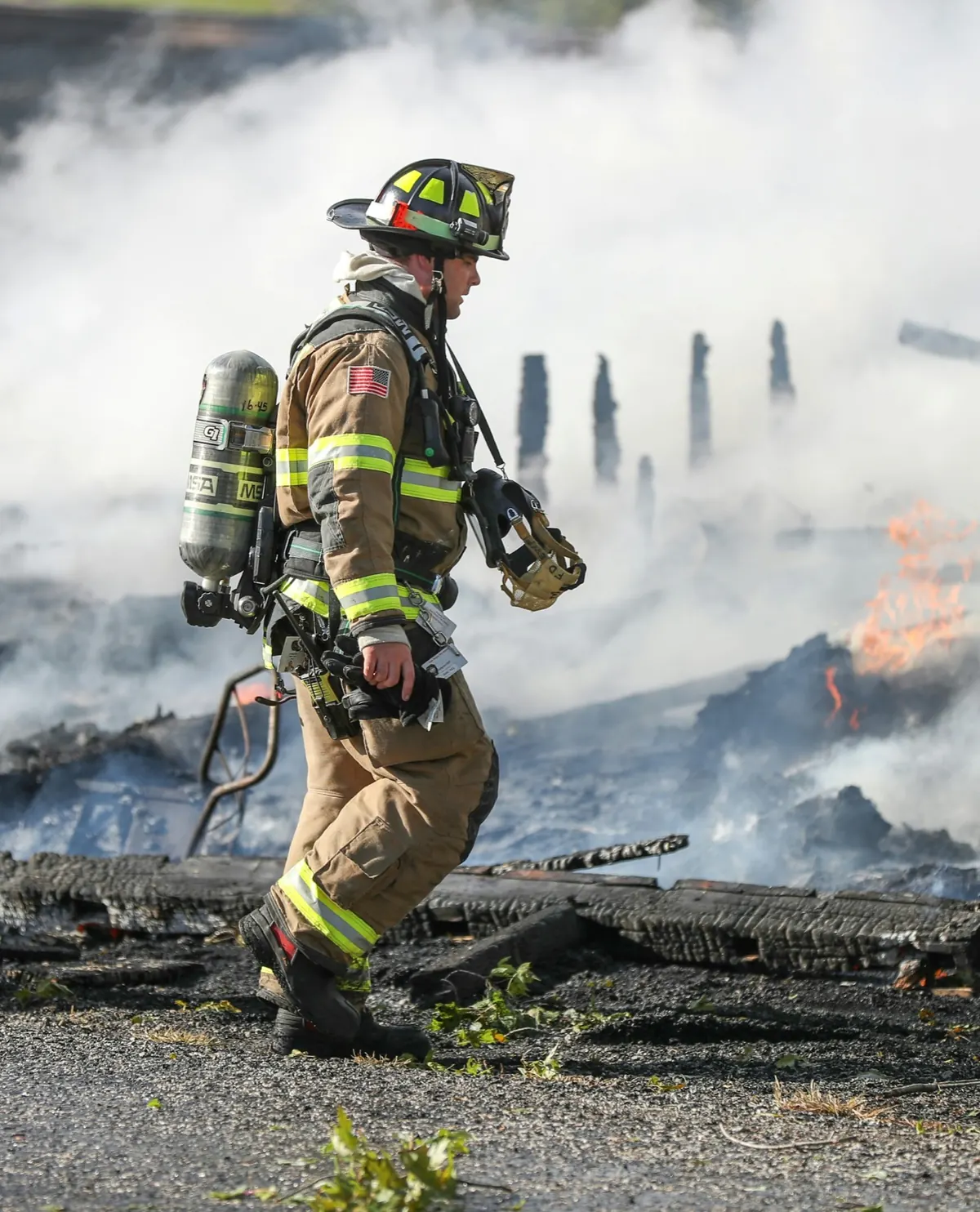Bombero caminando entre los restos de un incendio recién controlado